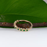 14K yellow gold band with round Zambian emerald accents