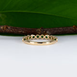 14K yellow gold band with round Zambian emerald accents