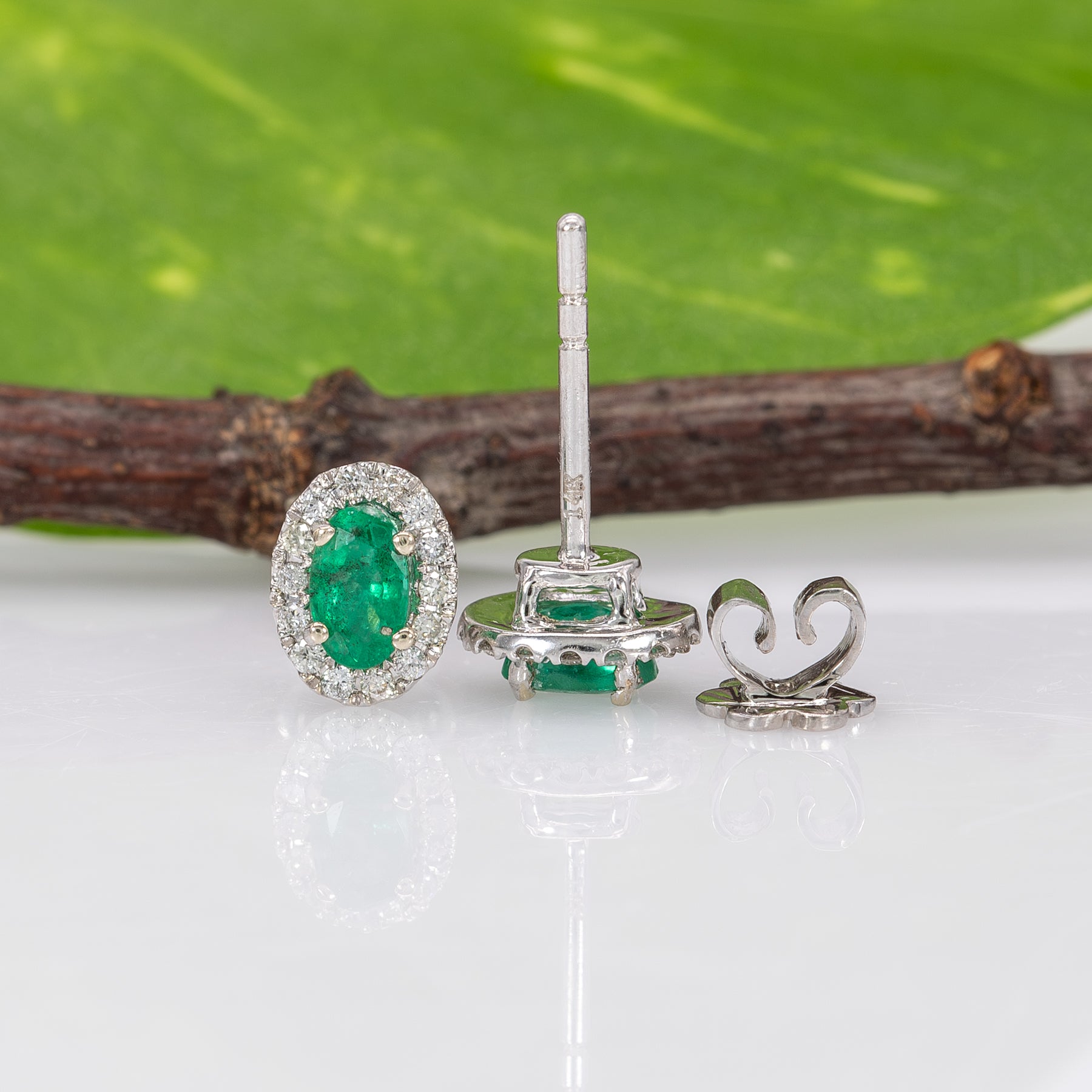 14K white gold emerald oval stud earrings with diamond halo
