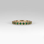 14K yellow gold band with round Zambian emerald accents
