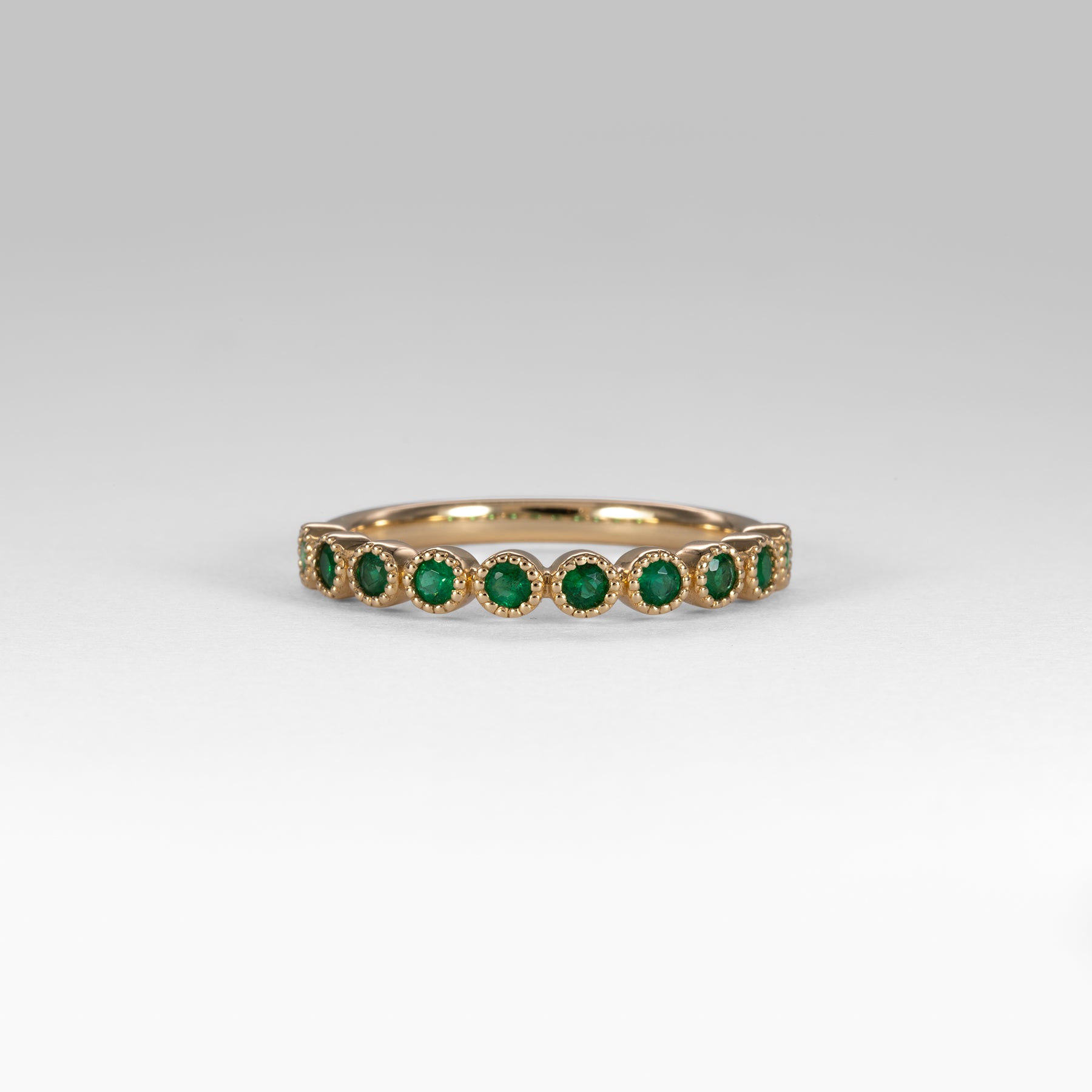 14K yellow gold band with round Zambian emerald accents