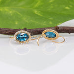 14K yellow gold London blue topaz oval stud earrings with diamond halo