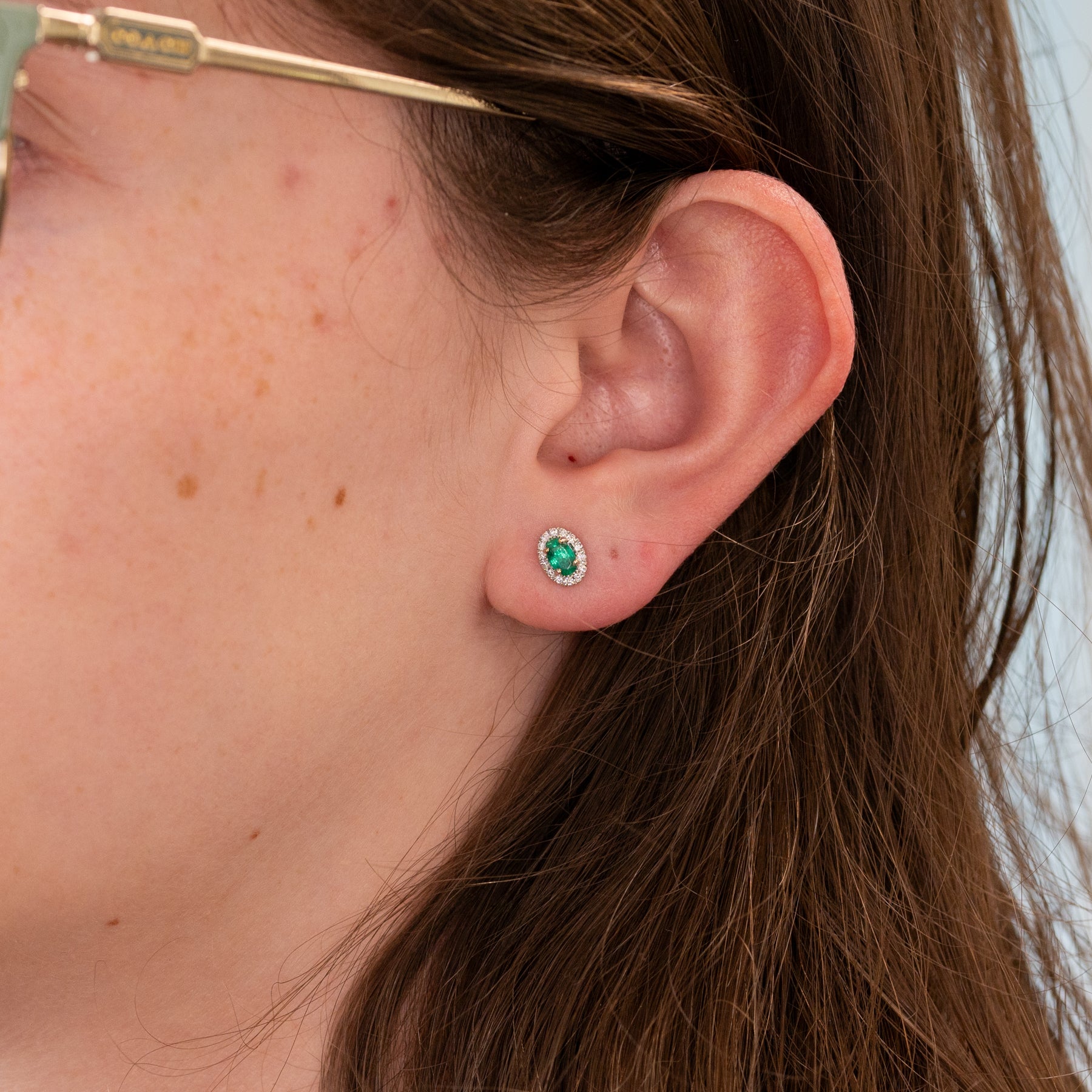 14K white gold emerald oval stud earrings with diamond halo