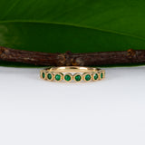 14K yellow gold band with round Zambian emerald accents