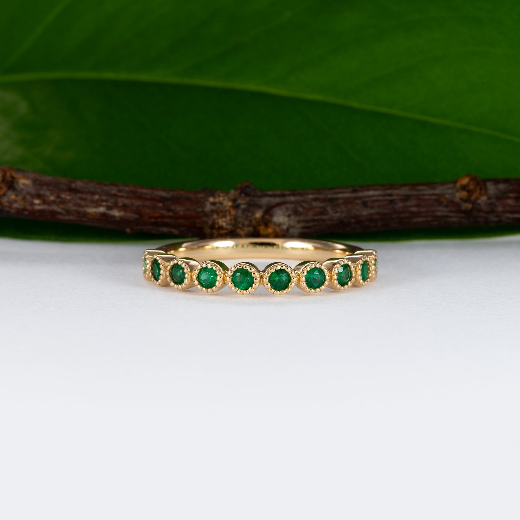 14K yellow gold band with round Zambian emerald accents