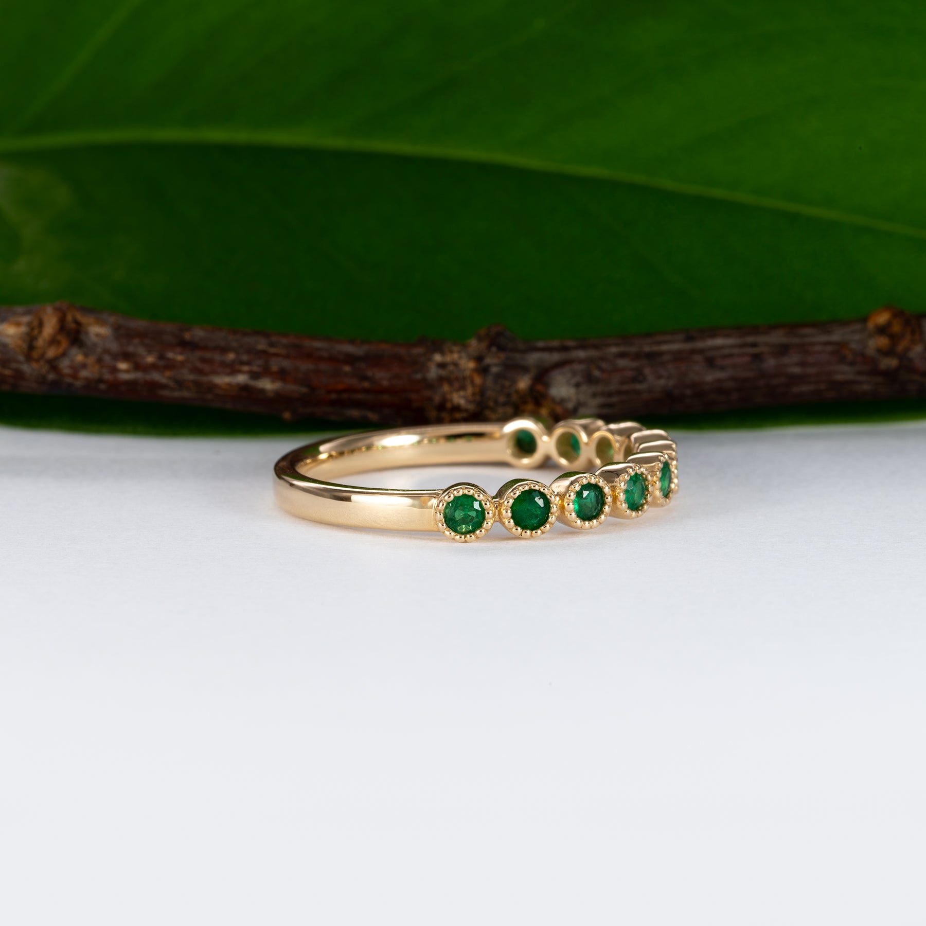 14K yellow gold band with round Zambian emerald accents