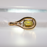 Sphene oval pendant with diamond accents in 14k yellow gold
