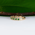 14K yellow gold band with round Zambian emerald accents