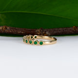 14K yellow gold band with round Zambian emerald accents